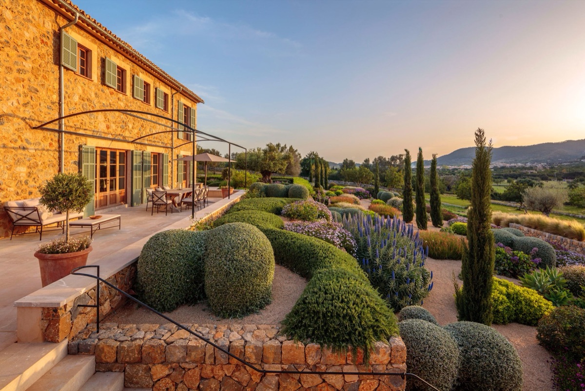A stone finca above clipped mounds and cypresses in Mallorca, by Mashamba Design