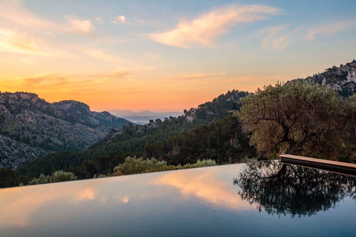 An infinity pool mirroring the mountains at sunset, Mallorca
